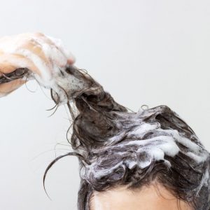 a-girl-washes-her-hair-with-shampoo-on-white-background-front-view-woman-female-banner-white-soap_t20_Jo0lN4